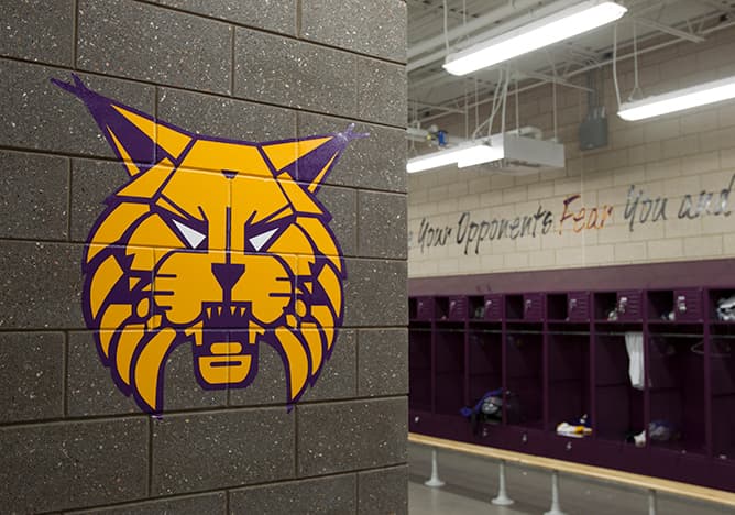 School wildcat mascot printed on a block locker-room wall